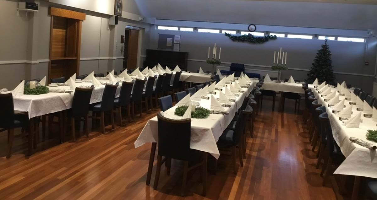 Blue chairs and white table cloths on long banquet style tables